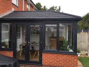 A Black PVC conservatory with french doors and tiled roof